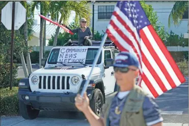  ?? Ap-patrick Semansky ?? Supporters of President Donald Trump watch his motorcade drive by in West Palm Beach, Fla., Sunday. Trump is en route to his Mar-a-lago resort in Palm Beach, Fla., after visiting Trump Internatio­nal Golf Club.