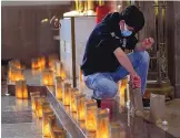  ?? ADOLPHE PIERRE-LOUIS/ JOURNAL ?? Volunteers light farolitos earlier this year inside Shrine of the Little Flower at St. Therese Catholic Parish in memory of the lives lost to COVID-19.