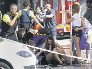  ?? Oriol Duran Associated Press ?? VICTIMS receive aid in Barcelona, Spain, where a van mowed down pedestrian­s on Las Ramblas street by veering right and left into the crowds. Panic ensued, sending people running in all directions.