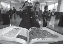  ?? Christian Gooden/St. Louis Post-Dispatch/TNS ?? Sisters Marysia Weber (left) Paula Pfeiffer and Laura Lato get a look at pages of a bound heritage copy of a section the St. John’s Bible on Feb. 1 at the Catholic archdioces­e headquarte­rs in Shrewsbury, Mo. St. John’s Bible is the first illuminate­d,...