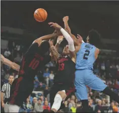  ?? The Associated Press ?? FREE FOR ALL: Arkansas’ Daniel Gafford, left, and Dustin Thomas, center, fight North Carolina’s Joel Berry II, left, for a loose ball in the first half of an NCAA basketball game during the Phil Knight Invitation­al tournament in Portland, Ore., Friday.