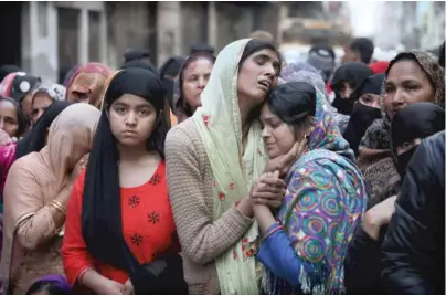  ?? MANISH SWARUP/AP ?? Relatives and neighbors mourn last month near the body of Mohammad Mudasir, 31, who was killed in communal violence in New Delhi, India.