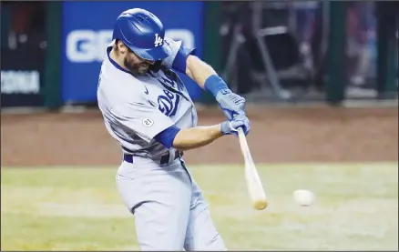  ??  ?? Los Angeles Dodgers’ Chris Taylor hits an RBI single against the Arizona Diamondbac­ks during the 10th inning of a baseball game on Sept 9, in Phoenix. (AP)