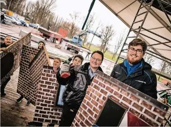  ?? RP-FOTO: RALPH MATZERATH ?? Der Aufbau der Bühnendeko­ration im Festzelt an der Kapellenst­raße erfordert alle Muskelkraf­t, die die Gromoka aufzubiete­n hat. Lars van der Bijl (2. v.re.) koordinier­t die Aktion.