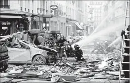  ?? THOMAS SAMSON/GETTY-AFP ?? Firefighte­rs work the scene after the explosion at a bakery Saturday on a corner in central Paris. Authoritie­s said 200 firefighte­rs and police were involved in the operation.