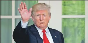  ??  ?? U.S. President Donald Trump waves as he returns to the Oval Office of the White House in Washington Thursday after speaking about the U.S. role in the Paris climate change accord.