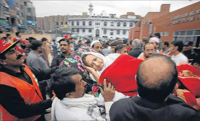  ?? MOHAMMAD SAJJAD / AP ?? Una mujer herida es trasladada a un hospital en la ciudad pakistaní de Peshawar