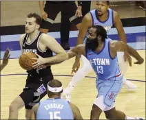  ??  ?? Rockets guard James Harden reaches in against the Sacramento Kings’ Nemanja Bjelica, who goes to the basket on Thursday in Houston.