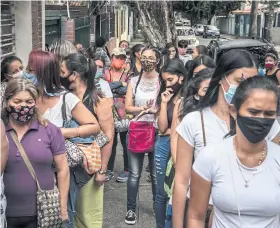  ??  ?? ABOVE
Women line up outside of Plafam, a non-profit women’s health clinic, in Caracas.