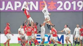  ?? AFP ?? Tonga's lock Sam Lousi (L) makes a catch during their World Cup match against England.