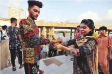  ?? AP ?? A Pakistani Hindu girl ties rakhi (ceremonial thread) on her brother’s wrist during Raksha Bandhan at a temple in Karachi