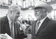  ?? Bob Owen / Staff photograph­er ?? Agricultur­e Commission­er Sid Miller, right, speaking with Railroad Commission­er Wayne Christian, says he is a staunch defender of consumer protection­s.