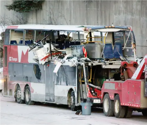  ?? DAVID KaWAI ?? The extent of damage to the upper deck of the bus that crashed into the Westboro Transitway station on Friday afternoon is revealed as the wreckage is towed from the scene. Three people were killed and as of Sunday night seven remained in serious condition in The Ottawa Hospital.