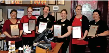  ??  ?? Staff members Angie Glass, Nicole Haire, general manager Mark Abbey, Bess Kurteschi, Tammy Kuntz and Melissa Pohl pose with the seven awards received by the Smitty’s Town ‘N’ County Mall location.