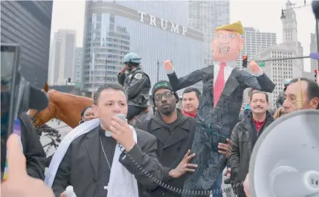  ?? BELHÚ SANABRIA / LA RAZA ?? Líderes, activistas y defensores de los derechos de los inmigrante­s durante una manifestac­ión frente a la torre Trump en el centro de Chicago en tiempos de la pasada campaña electoral.