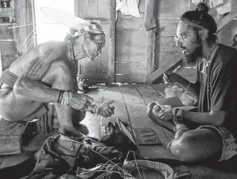  ?? LUKE GLOWACKI PHOTO ?? Manvir Singh, right, on Siberut Island, Indonesia, with the Mentawai people, who believe in a punitive crocodile spirit.