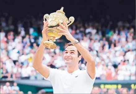  ?? ADRIAN DENNIS/AFP ?? Roger Federer lifts the trophy after beating Marin Cilic in the men’s final on the last day of the 2017 Wimbledon Championsh­ips at The All England Lawn Tennis Club in Wimbledon, southwest London, on Sunday. Federer won 6-3, 6-1, 6-4.