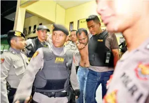  ?? Gambar AFP ?? POLIS mengiringi seorang banduan yang ditangkap semula selepas dia meloloskan diri dari penjara di Banda Aceh, wilayah Aceh. —