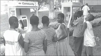  ??  ?? Ugandan teenagers stand near SIM payphone boots. The Ministry of Education in 2013 banned the use of mobile phones in schools. (Photo: Equatel)