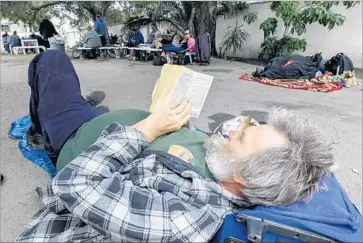  ?? Irfan Khan Los Angeles Times ?? MIKE ALBRIGHT, 58, reads a book at a Pomona homeless shelter. According to the latest annual count, about three-fourths of L.A. County’s homeless population — or just under 43,000 people — are unsheltere­d.