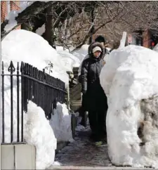  ?? The Associated Press ?? Pedestrian­s walk single file through snow banks on a Beacon Street sidewalk in Boston, Friday. Midway through an epic winter that's shattered records and buried Boston in more than 8 feet of snow, locals and outsiders alike could be forgiven for...