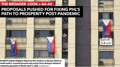  ?? AP/AARON FAVILA ?? RESIDENTS display Philippine flags from their windows as they pay tribute to health workers, essential personnel and security forces during an enhanced community quarantine in Manila, April 12, 2020.
