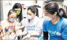  ?? PROVIDED TO CHINA DAILY ?? UNICEF Hong Kong Chairman Judy Chen (second from right) and UNICEF HK Ambassador Guo Jingjing (right) give an anti-coronaviru­s package on Tuesday to one of the local children who live in a subdivided apartment.