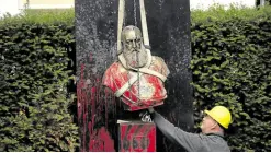  ?? —AP ?? ROI RACISTE A worker removes a bust of Belgium’s King Leopold II from a park in Ghent, Belgium, on Tuesday.
