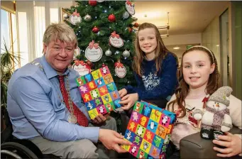  ??  ?? The Mayor of the County of Cork, Clllr. Patrick Gerard Murphy, gives a Christmas present to cousins Áine O’Donovan (9) and Niamh Walsh (11) at the launch of the Shop Local Think Cork County campaign.