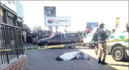  ?? PICTURE: JOZI FM ?? DEAD END: A robber lies dead outside a bank in Soweto. He was alleged to have been part of a gang of three who tried to rob a man at an ATM. The victim strangled him to death.