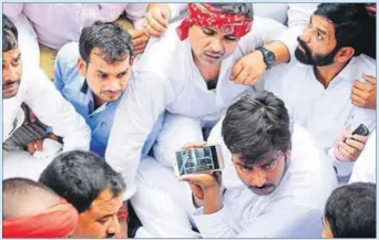  ?? DEEPAK GUPTA/HT ?? Supporters of Uttar Pradesh chief minister Akhilesh Yadav listen to news outside the Samajwadi Party office during a party meeting to resolve difference­s, in Lucknow on Monday.