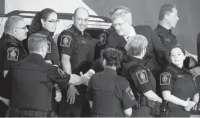  ?? JONATHAN HAYWARD/THE CANADIAN PRESS ?? Prime Minister Stephen Harper shakes hands with Canadian border agents after announcing in Richmond, B.C., Monday, legislatio­n this fall to protect children against child sexual exploitati­on.