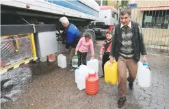  ??  ?? DAMASCUS: In Jan 16, 2017 photo, people carry plastic containers with water in Damascus, Syria. Water cut-offs have been almost continuous since Dec 22, in the worst water crisis known to Damascus residents. — AP