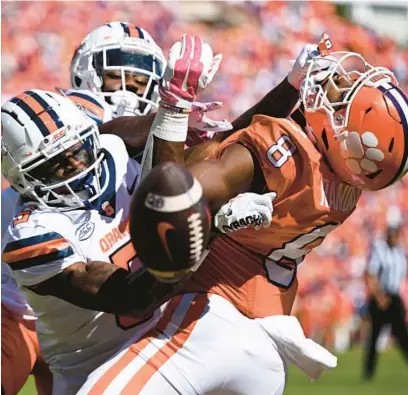  ?? EAKIN HOWARD/GETTY ?? Syracuse’s Darian Chestnut (0) and Alijah Clark (5) break up a pass meant for Clemson’s Adam Randall on Saturday in Clemson, South Carolina.