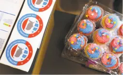  ??  ?? Above: Cupcakes and stickers, rewards for National Voter Registrati­on Day, are displayed Tuesday at Alliant Internatio­nal University’s Hurwich Library near Pier 39. At top: Alliant psychology student Christine Libbey says she’s taking voting more seriously this year.