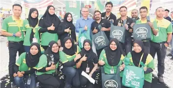  ??  ?? Pierre (standing, fifth left) together with Giant employees giving their thumbs up for the launch of Giant’s 1,000,000 reusable bags giveaway in support of conservati­on efforts.