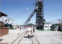  ?? PICTURE: REUTERS ?? Mine workers walk past the pit head at Sibanye Gold’s Masimthemb­e shaft in Westonaria.