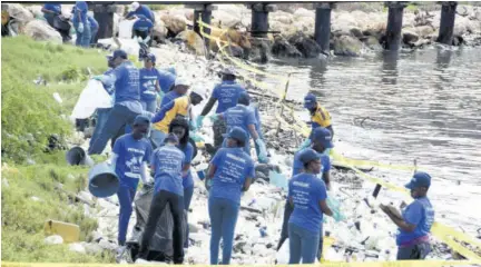  ?? (Photo: Garfield Robinson) ?? Volunteers assisting with last year’s beach clean-up. The TPDCO believes the ban on plastic bags as well as recycling of plastic bottles will help to preserve the environmen­t.