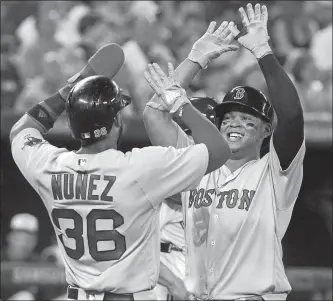  ?? FRED THORNHILL/THE CANADIAN PRESS VIA AP ?? Boston’s Rafael Devers high-fives with Eduardo Nunez after Devers hit a two-run home run during the sixth inning of Wednesday’s game against the Blue Jays at Toronto. Boston won, 10-5.