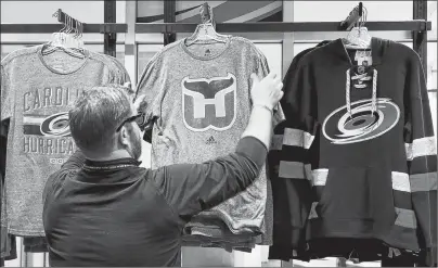  ?? CHRIS SEWARD/THE NEWS & OBSERVER VIA AP ?? Kurt Cusac, a worker at The Eye store, straighten­s out Hartford Whalers T-shirts before the doors opened before an NHL game played between the Carolina Hurricanes and the Montreal Canadiens at PNC Arena in Raleigh, N.C., Feb. 1, 2018. It’s the first...