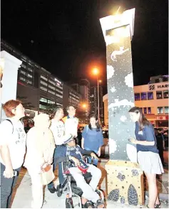  ??  ?? HongYi (right), Baya (third left) and invited guests listening to Awang Fadilah as he explained about his artwork on the pillar.