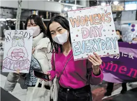  ?? TAKASHI AOYAMA GETTY IMAGES ?? Participan­ts hold signs and shout slogans during the Women’s March Tokyo on Wednesday in Tokyo, Japan.