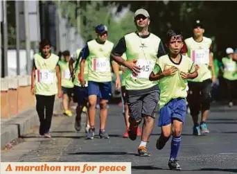  ?? AP ?? Runners take part in the Baghdad Marathon for peace, security and against violence along Abu Nawas Street in central Baghdad, Iraq, yesterday.