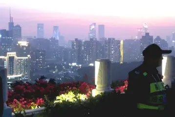  ??  ?? A security personnel stands guard at a viewing platform overlookin­g the central business area ahead of the 40th anniversar­y of China’s reform and opening up in Shenzhen, Guangdong province, China. — Reuters photo