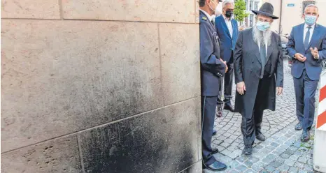  ?? FOTO: STEFAN PUCHNER/DPA ?? Eine Woche nach dem Brandansch­lag auf die Synagoge in Ulm ist Innenminis­ter Thomas Strobl (CDU, rechts) am Freitagabe­nd zu einer Solidaritä­tsveransta­ltung in die Stadt gekommen. Rabbiner Shneur Trebnik zeigt ihm den Rußfleck, der bei der Tat entstanden ist.