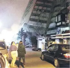  ??  ?? ► Taiwaneses observan un edificio colapsado tras el sismo en Hualien.