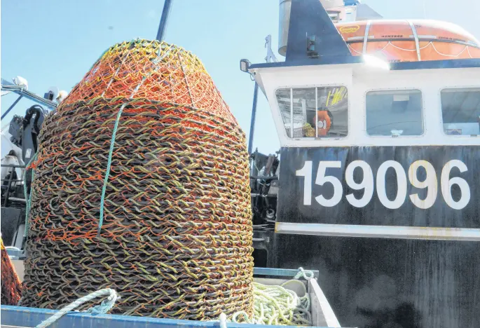  ?? JOE GIBBONS FILE PHOTO • THE TELEGRAM ?? Crab pots, like these waiting to be loaded onto the Dalton Princess on the St. John’s waterfront on April 11, are ready to be set now that harvesters and processors have resolved an impasse over the pricing formula for snow crab that delayed the season for nine days.