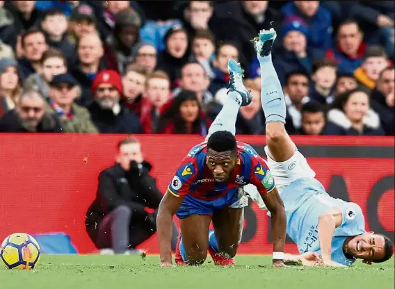  ?? — Reuters ?? C-r-a-s-h: Manchester City’s Danilo goes crashing after colliding with Crystal Palace’s Timothy Fosu-Mensah in the English Premier League match at Selhurst Park yesterday.