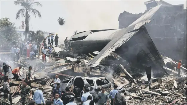  ?? Picture: Getty ?? Rescue workers in Medan search for victims at the scene where an Indonesian military C-130 Hercules crashed into a residentia­l area shortly after take-off