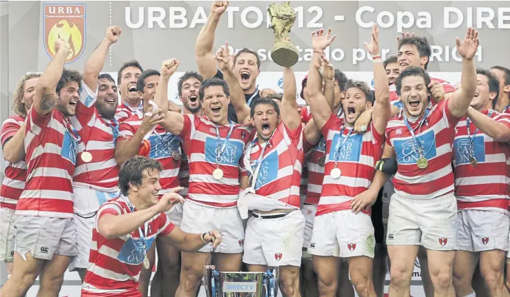  ??  ?? la celebració­n de los jugadores de Alumni, con la copa del Top 12 de la uRBA y, especialme­nte, con el trofeo de madera tan simbólico para el club